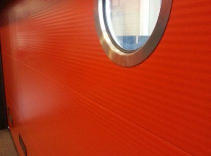 detail of a round window on an insulated sectional red door